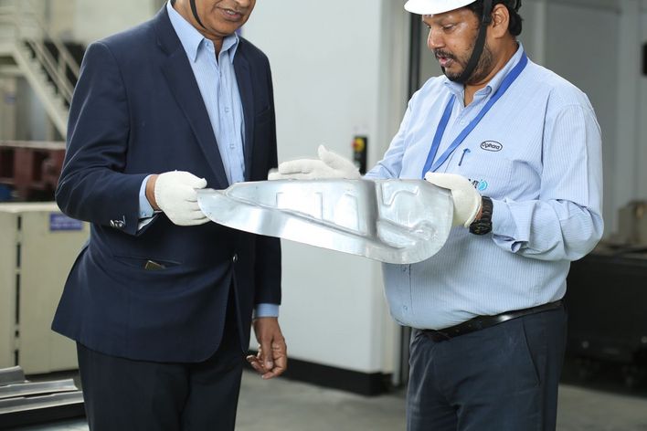 B. B. Gupta (links), Präsident Strategy & Business Planning von JBM Auto Components, und General Manager Ajit Choudhary inspizieren Bauteile, die mit der TruLaser Cell 7040 beschnitten wurden.