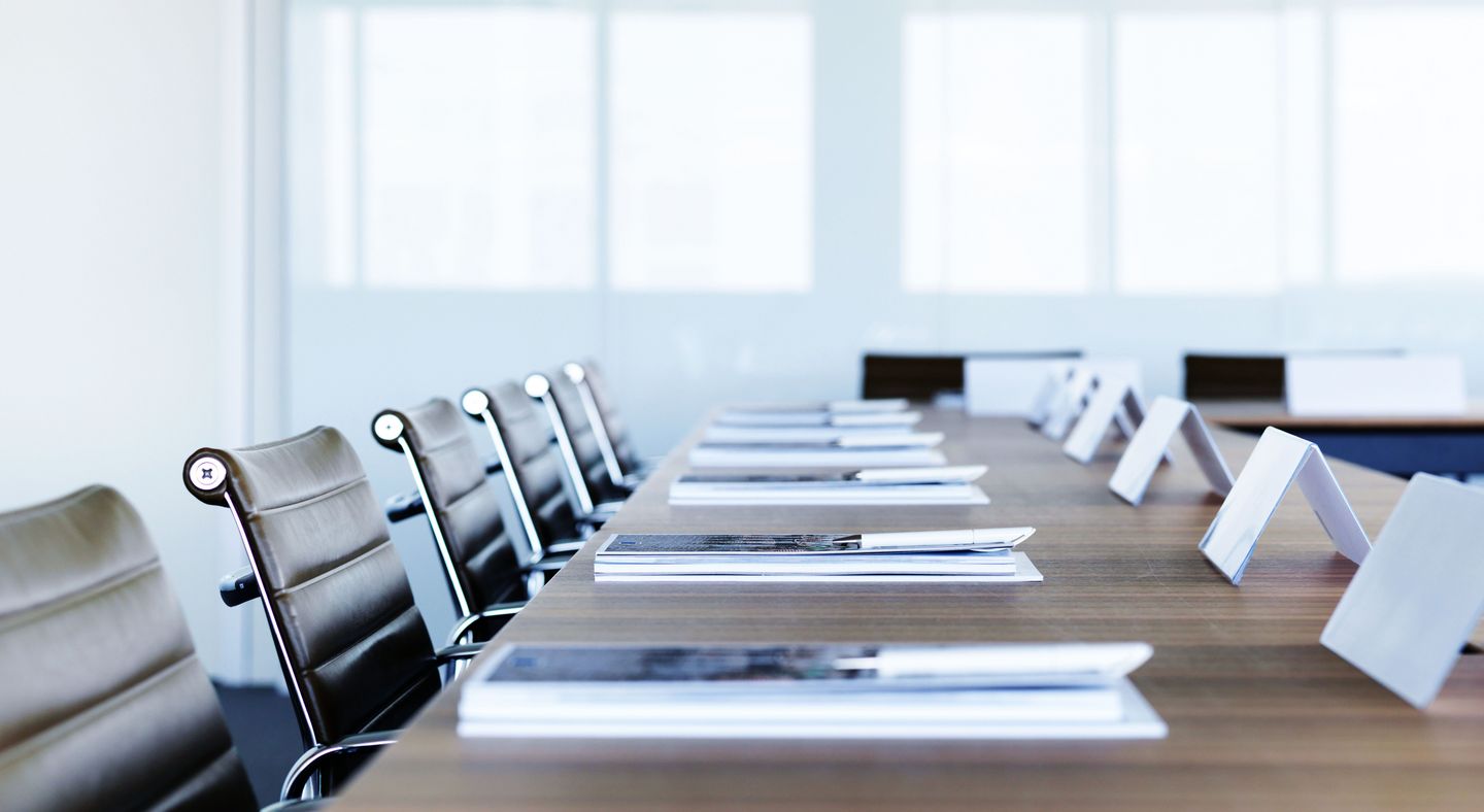 配有桌椅的会议室，桌上有若干办公材料 