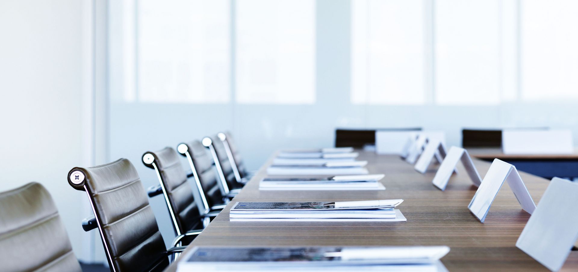 配有桌椅的会议室，桌上有若干办公材料 