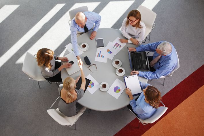 High,Angle,View,Of,Business,People,Sitting,At,Meeting,And