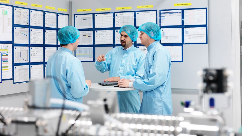 一组通快员工在谐振腔组装洁净室中进行商务会议