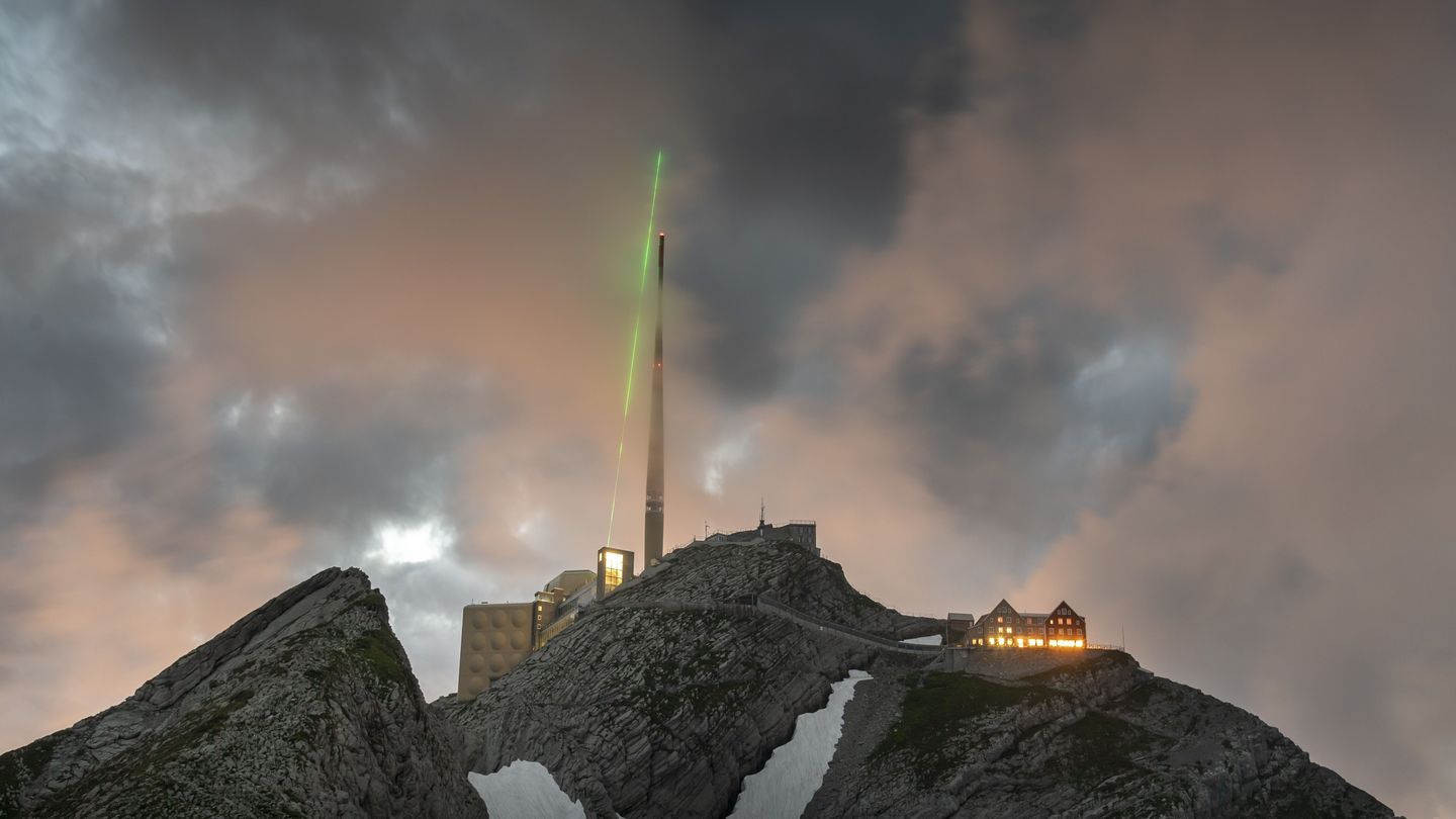 Grüner Laser auf Bergspitze