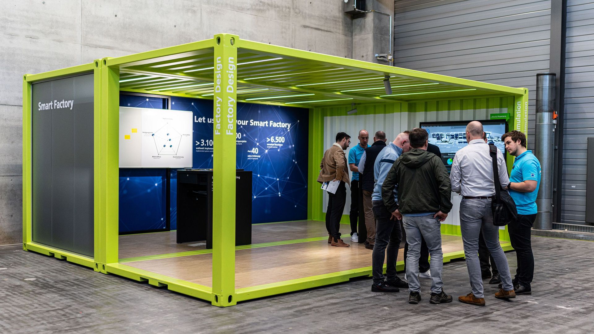 Menschengruppen stehen vor und im Smart Factory Container
