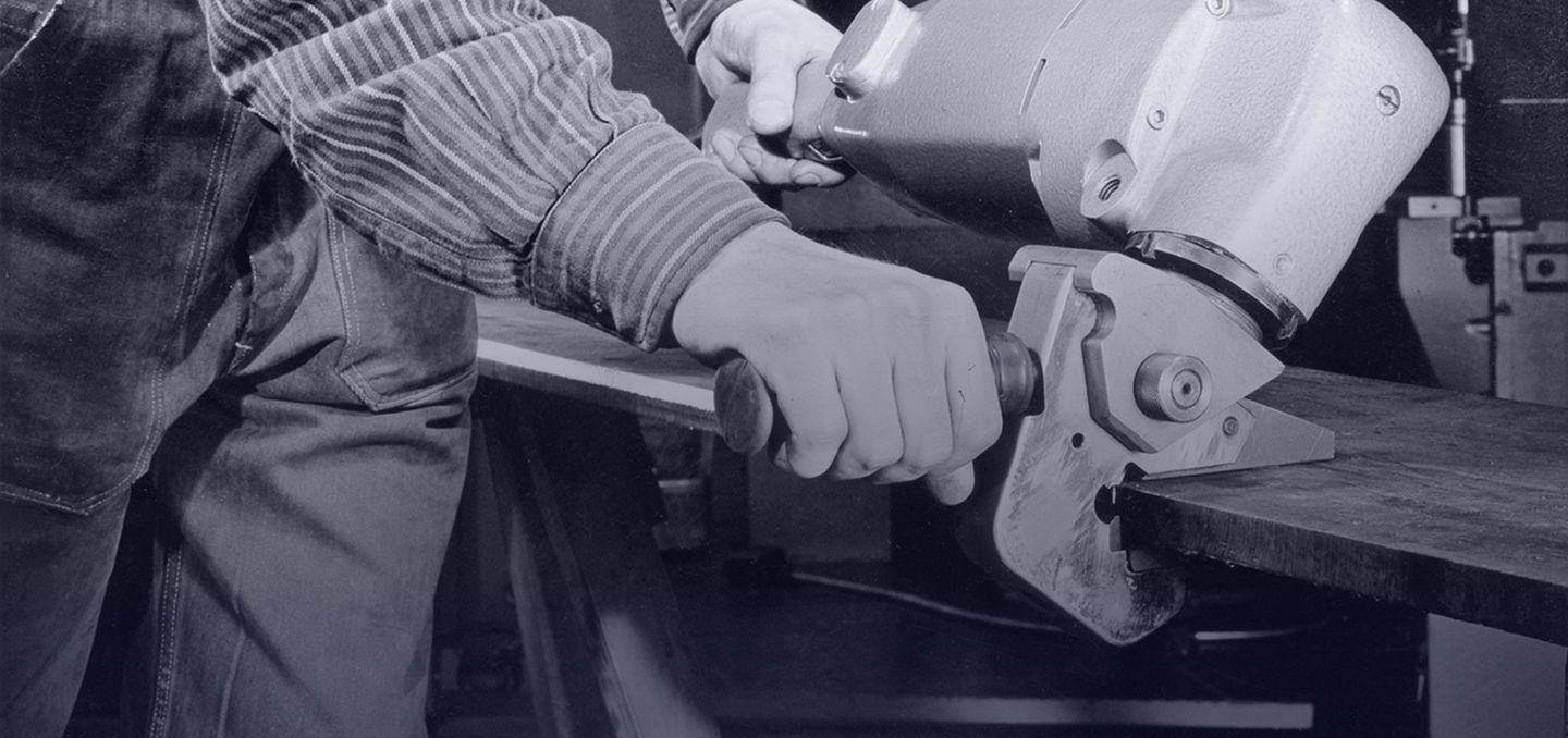 historical picture showing a worker with a deburrer