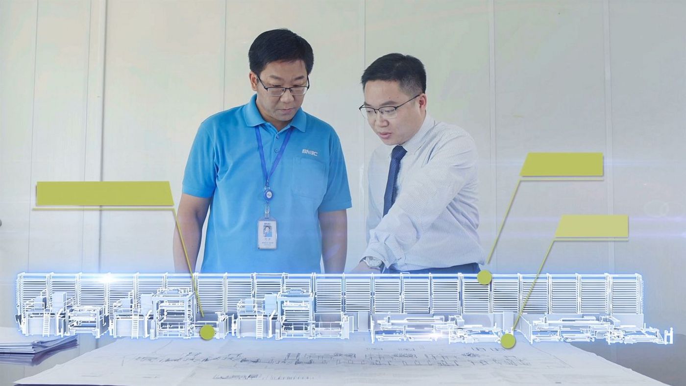 Colleagues in front of a miniature model of production