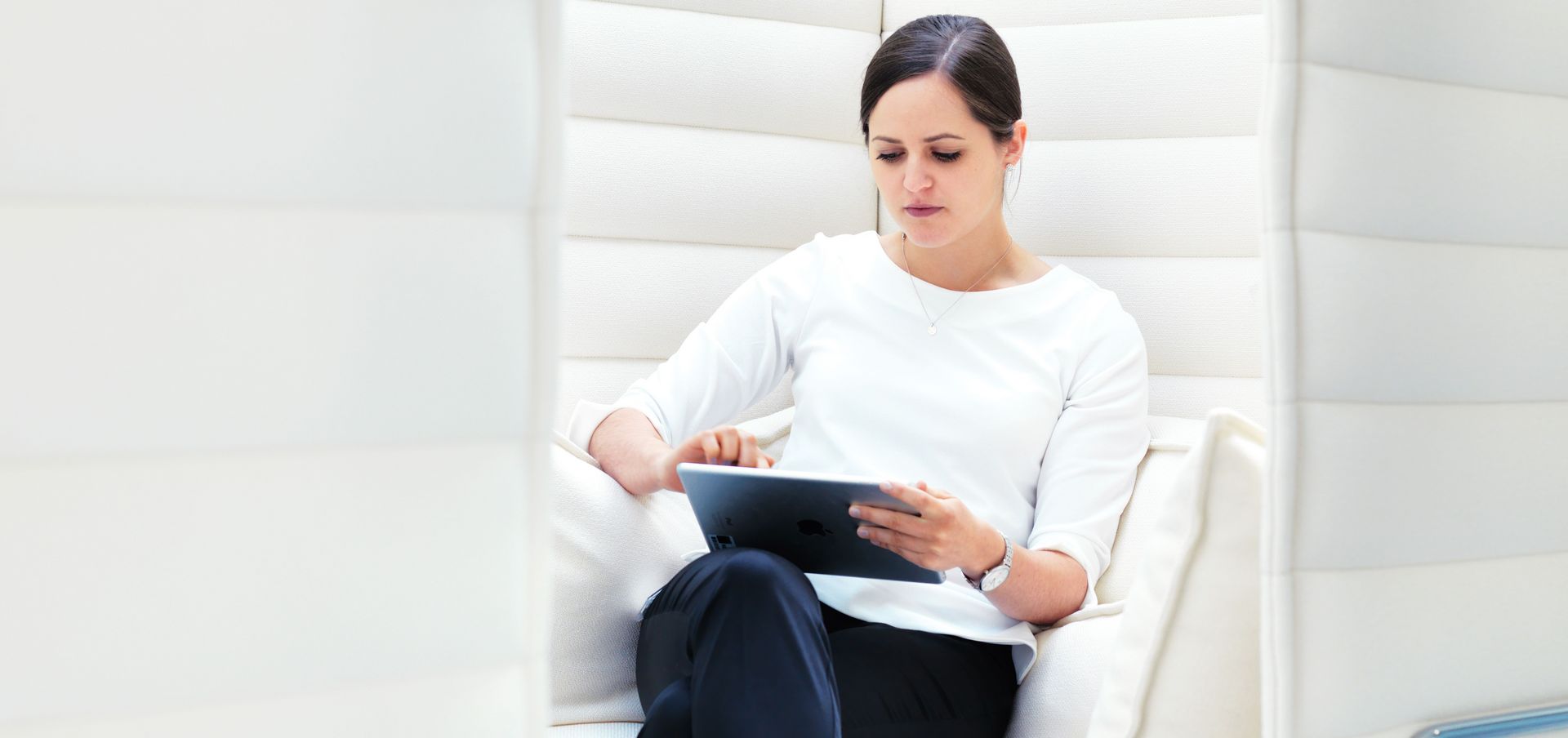 一位通快员工坐在休息区并使用移动设备工作